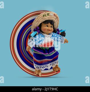 Female doll in colorful traditional clothes of Mexican people on a blue background. Circular Pixel Stretch Effect. Stock Photo