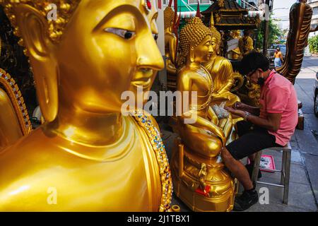 Bangkok, Thailand. 17th Mar, 2022. A craftsman seen decorating a buddha statue in Bangkok's inner zone. Rattanakosin Island, Bangkok's inner area is the core of the historical and cultural zone of Bangkok. This place is also known as an old town because of the ages of the zone that more than 100 years of existence. Not only palace, temples, and landmarks this zone include the life and activities of the human who live around the sacred area of Bangkok. (Photo by Varuth Pongsapipatt/SOPA Images/Sipa USA) Credit: Sipa USA/Alamy Live News Stock Photo