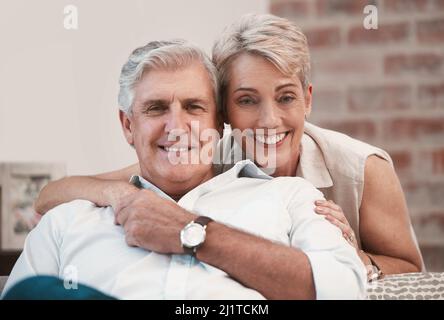 A lifetime of bonding. Portrait of an affection mature couple posing for a picture on the sofa together at home. Stock Photo