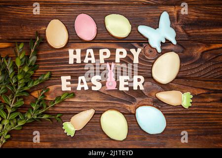 Happy Easter holiday greeting on dark brown wooden background. Stock Photo