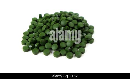 Spirulina algae tablets isolated on white background. Nutritional supplements, vitamins and health concept  Stock Photo