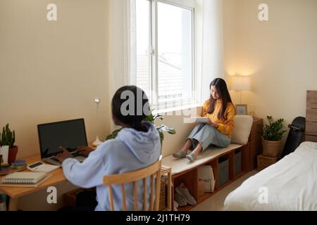 Serious female college students studying in dormitory Stock Photo