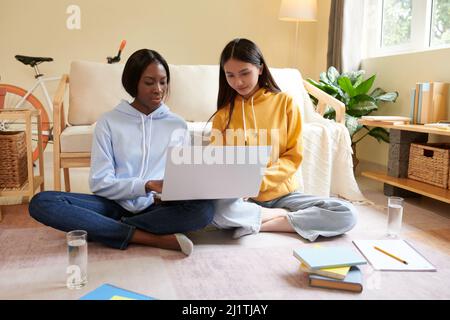 Young female college students watching educational video on laptop when working on project together Stock Photo