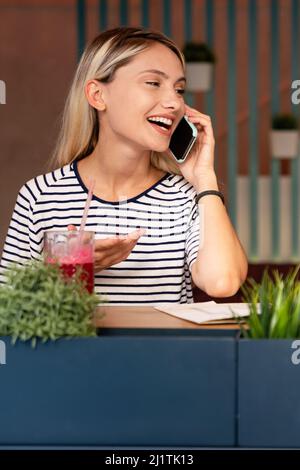 Portrait of happy woman smiling and using mobile phone. People technology social network concept Stock Photo