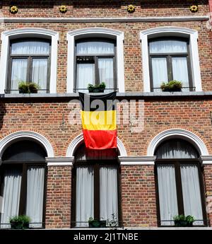 A Belgian flag hanged on a wall of a building in Brussels, Belgium. Stock Photo