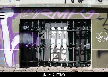 Old decorated window grille in front of old cellar window on colorful painted house wall, Germany, Europe Stock Photo