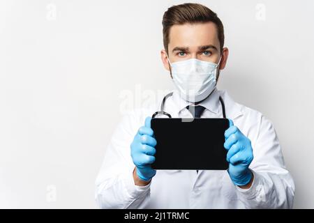 Young and confident doctor is using tablet pc Stock Photo