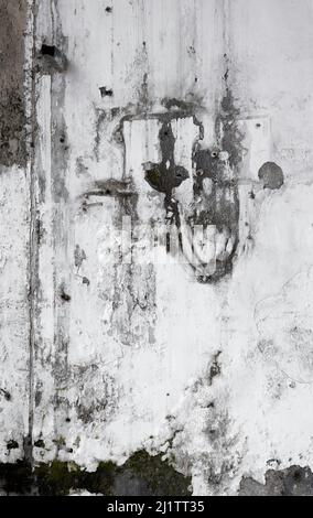 White cracked and peeling cement wall with natural abstract design in black mold. Stock Photo