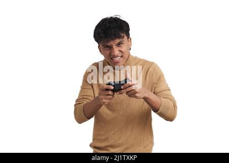Young peruvian man playing video games with a joystick, isolated. Stock Photo