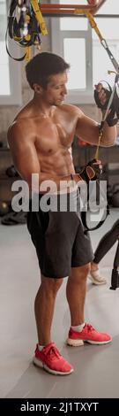 Strong man and beautiful slim woman doing exercises at gym Stock Photo