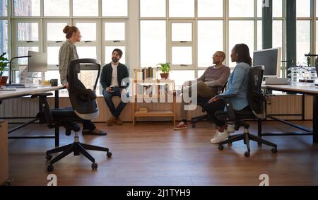 Young businesswoman talking with colleagues during an office meeting Stock Photo