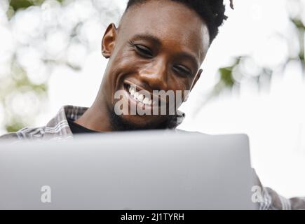 Dedicated and determined. Shot of a young man using a laptop on campus. Stock Photo