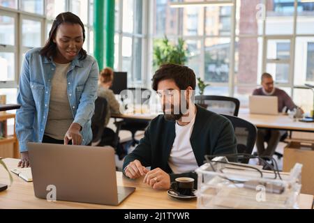 Two diverse young businesspeople working together on a laptop Stock Photo