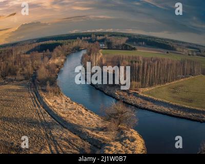 Sunset over a small river in the spring evening. Stock Photo