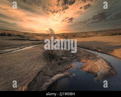 Sunset over a small river in the spring evening. Stock Photo