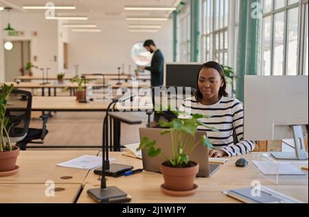 Focused young African businesswoman working at her desk in an office Stock Photo