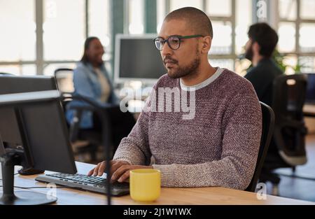Focused young businessman working on a computer in an office Stock Photo