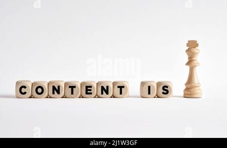 The word content is king written on wooden blocks with a king chess piece. Content creation and development strategy concept. Stock Photo