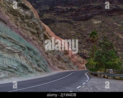 Beautiful landscape with colorful volcanic rocks of Los Azulejos De Veneguera in the mountains of west Gran Canaria island, Spain with country road. Stock Photo