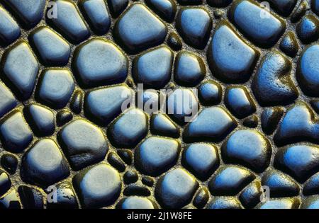 From above abstract background of stones of different shapes and sizes on wet ground on rainy day Stock Photo