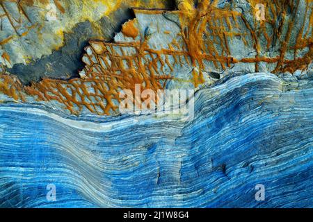 From below of massive rocky cliff with striped pattern in daytime as abstract background Stock Photo