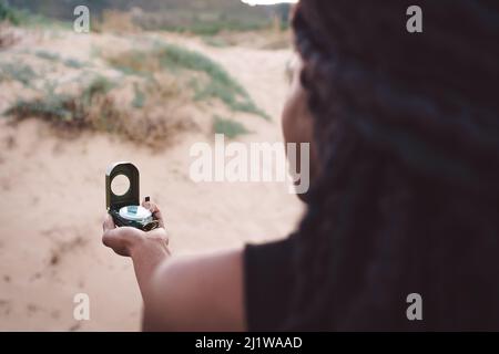 Modern African American female buyer in protective mask for coronavirus prevention using smart watch while standing near stall with grocery products i Stock Photo