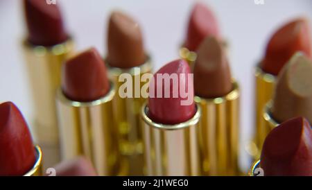 Closeup of tubes of lipsticks in different hues of red. Stock Photo
