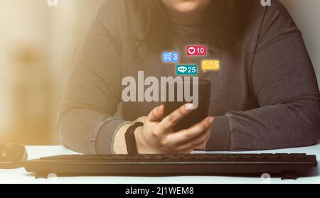 Woman using social media marketing interface on smartphone with notification icons. Social media concept with notifications. Stock Photo