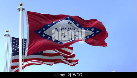 The flags of the Arkansas state and United States waving in the wind. Democracy and independence. US state flag Stock Photo