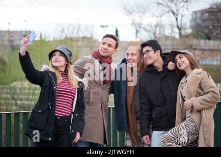 Group of friends of different ages and ethnicities taking a selfie outdoors. Stock Photo