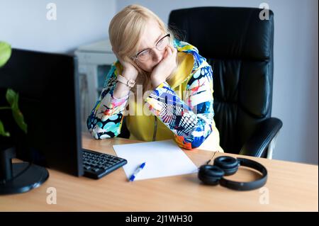 Middle aged tired, stressed and frustrated business woman desperate working at office with computer Stock Photo