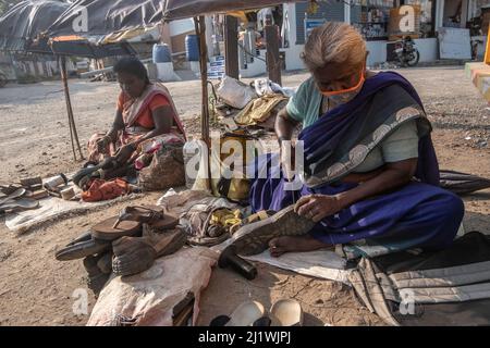 Shoemaker repairing a pair of sandals at the Marketplace at Tiruvannamalai, Tamil Nadu, India Stock Photo