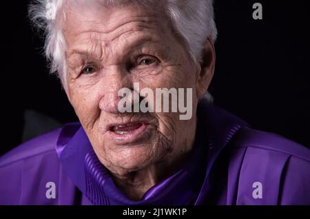 Portrait of serious senior woman against black background Stock Photo