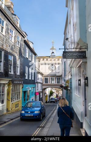 Clock in archway over the narrow high street, one way traffic, Totnes, Devon, UK Stock Photo