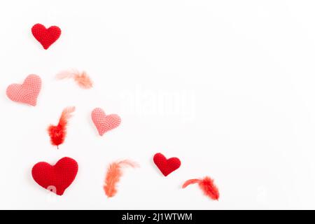 A holiday card with knitted hearts and feathers. Stock Photo