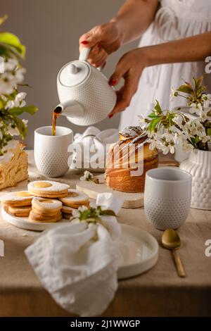 Happy easter. Traditional Easter cake , homemade kraffin with raisins,candied fruits .Cherry blossom on white beton background.Selective focus.Close u Stock Photo