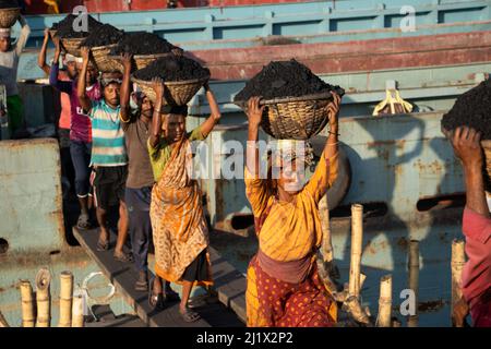 March 13, 2022, Dhaka, Dhaka, Bangladesh: Workers transport baskets full of coal on the top of their heads as they unload coal from a cargo ship in Dhaka. About 3.0 per cent of the countryâ€™s power currently comes from coal. In the early morning, workers start unloading coals till sunset, they earn USD $5 to $7 per day. There are no special shoes on their feet and no gloves in their hands to unload coal from cargo ships. Moreover, long working hours under the scorching sun, massive accumulation of dust and carrying excessive loads pose serious health hazards for the workers. (Credit Image: © Stock Photo