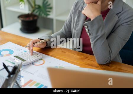 Business analyst concept the accountant using a calculator to figure out the number of the expense. Stock Photo