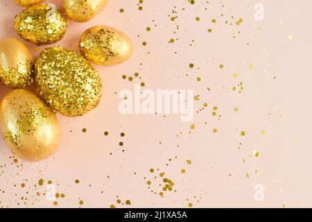 Easter eggs with gold sequins on a beige background. Stock Photo