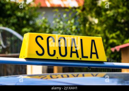 Driving school sign placed on top of car Stock Photo