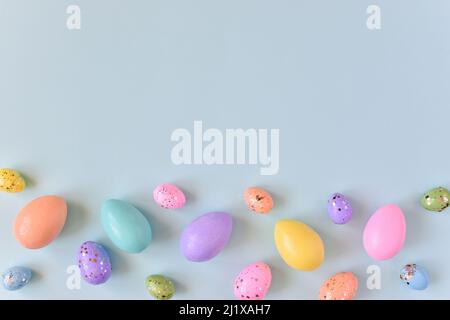 Easter card with eggs of delicate colors and sequins on a light Stock Photo