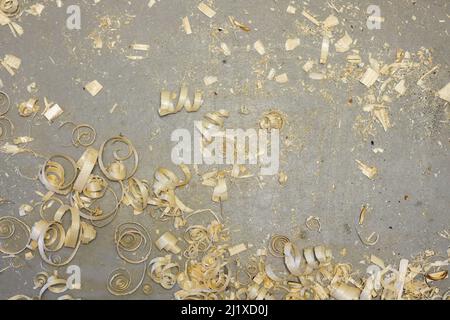 a small pile of wood shavings on a gray linoleum floor Stock Photo