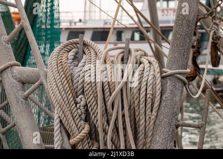 Various nautical ropes ready for use on deck of a commercial fishing boat in amarina in Rockport, Texas, in close up with limited focus and shallow de Stock Photo