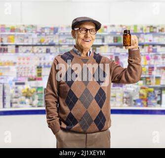 Elderly man holding a bottle of pills inside a chemist store Stock Photo