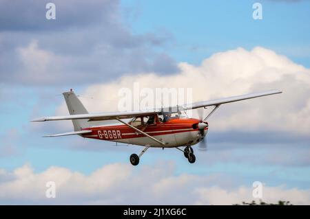 Reims F172 Skyhawk, French-built Cessna 172, plane G-BGBR taking part in flour bombing competition at Elmsett airfield. Co-pilot dropping bag Stock Photo