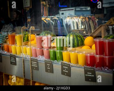 Juices and smoothies in plastic disposable cups on display at a Juice bar. Stock Photo