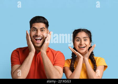 Great Deal. Amazed Arab Spouses Looking At Camera And Touching Face Stock Photo