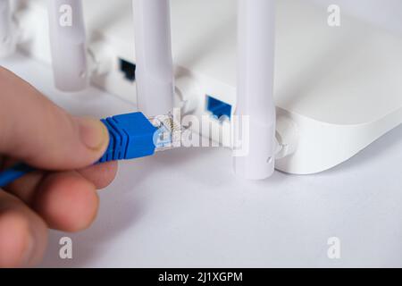 The wizard inserts the Internet cable into the Wi-Fi router. Internet connection Stock Photo