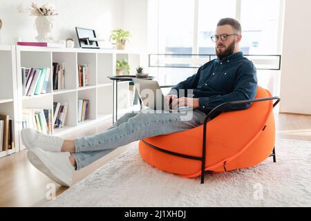 Freelancer Guy Using Laptop Working Online Browsing Internet Sitting Indoors Stock Photo