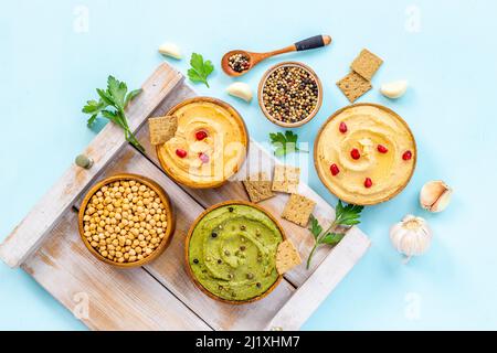 Flatlay of different types of colorful hummus in bowls. Vegan food ...